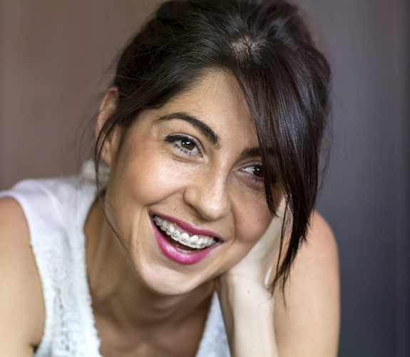 Woman sitting and smiling with braces in Naperville, IL