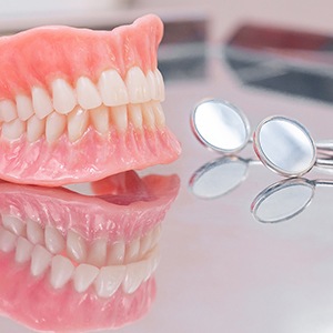 Man with missing teeth holding dentures