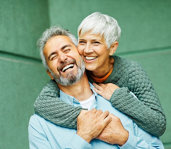 Couple smiling after learning how dentures are made in Naperville