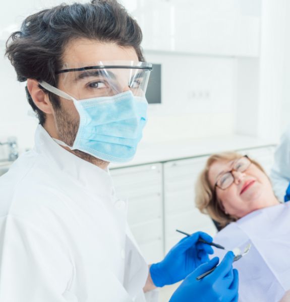 Doctor Montoya in protective gear treating dental patient