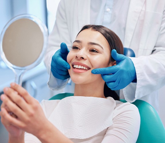 a patient smiling and examining their teeth