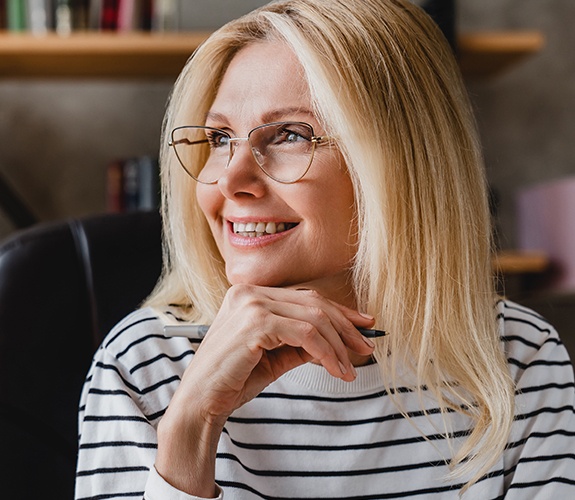 Woman smiling after dental implant tooth replacement