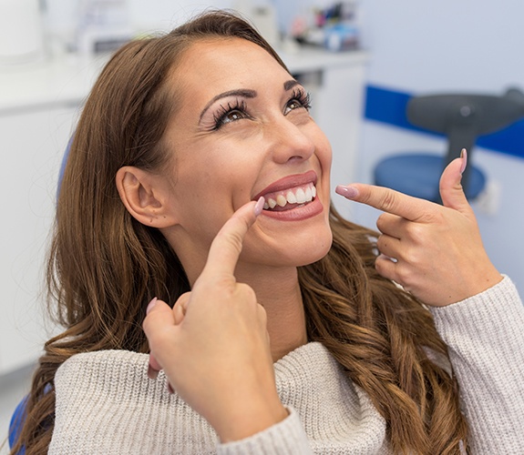 Woman pointing to smile after dental cleaning