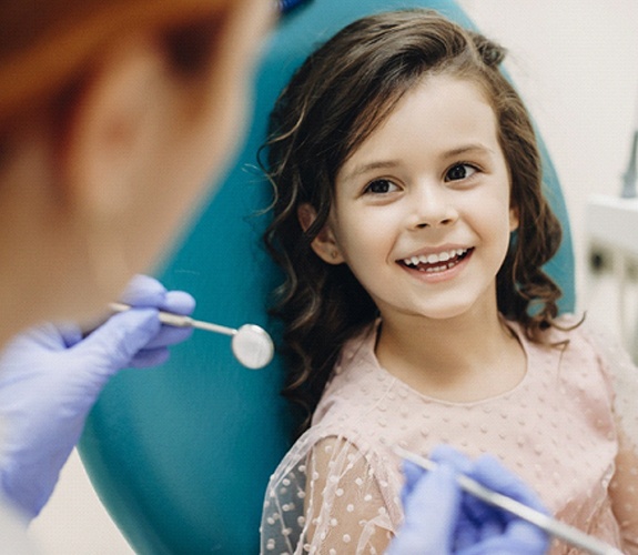 Little girl preparing for pulp therapy at dentist’s office
