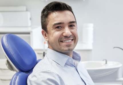 Man smiling after replacing missing teeth