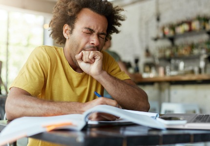 Man in need of sleep apnea therapy yawning