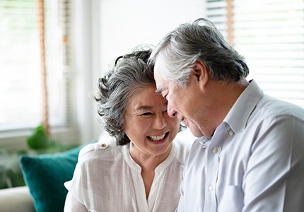 Man and woman with healthy smiles after gum disease treatment