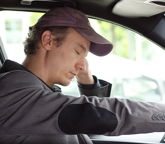 Man in need of sleep apnea therapy tired behind the wheel of his car