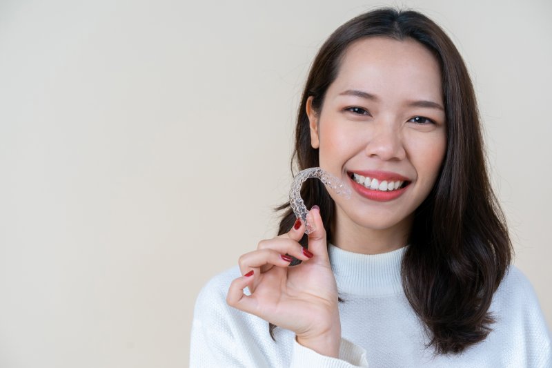 woman holding an Invisalign aligner