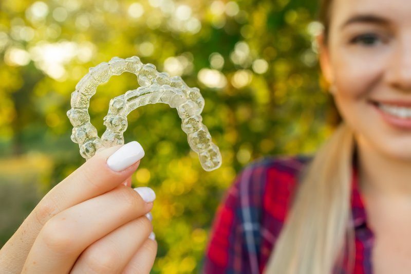 Teenage girl holding Invisalign aligners 