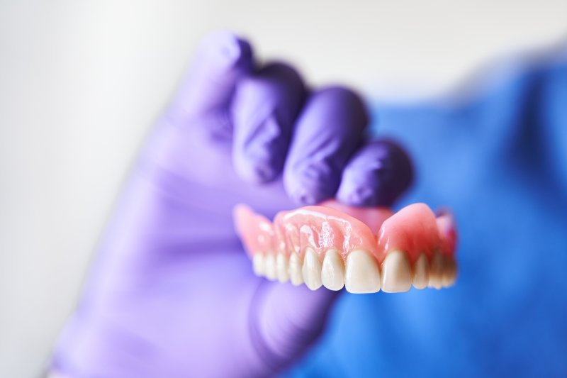 person holding a full upper denture