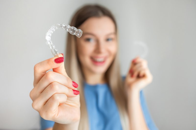 girl holding clear aligners